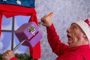 Bernie wrestling with Carl the mischievous gremlin-like Christmas present