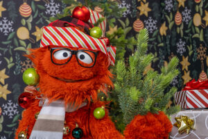 Sam covered in Christmas ornaments in a silly holiday moment